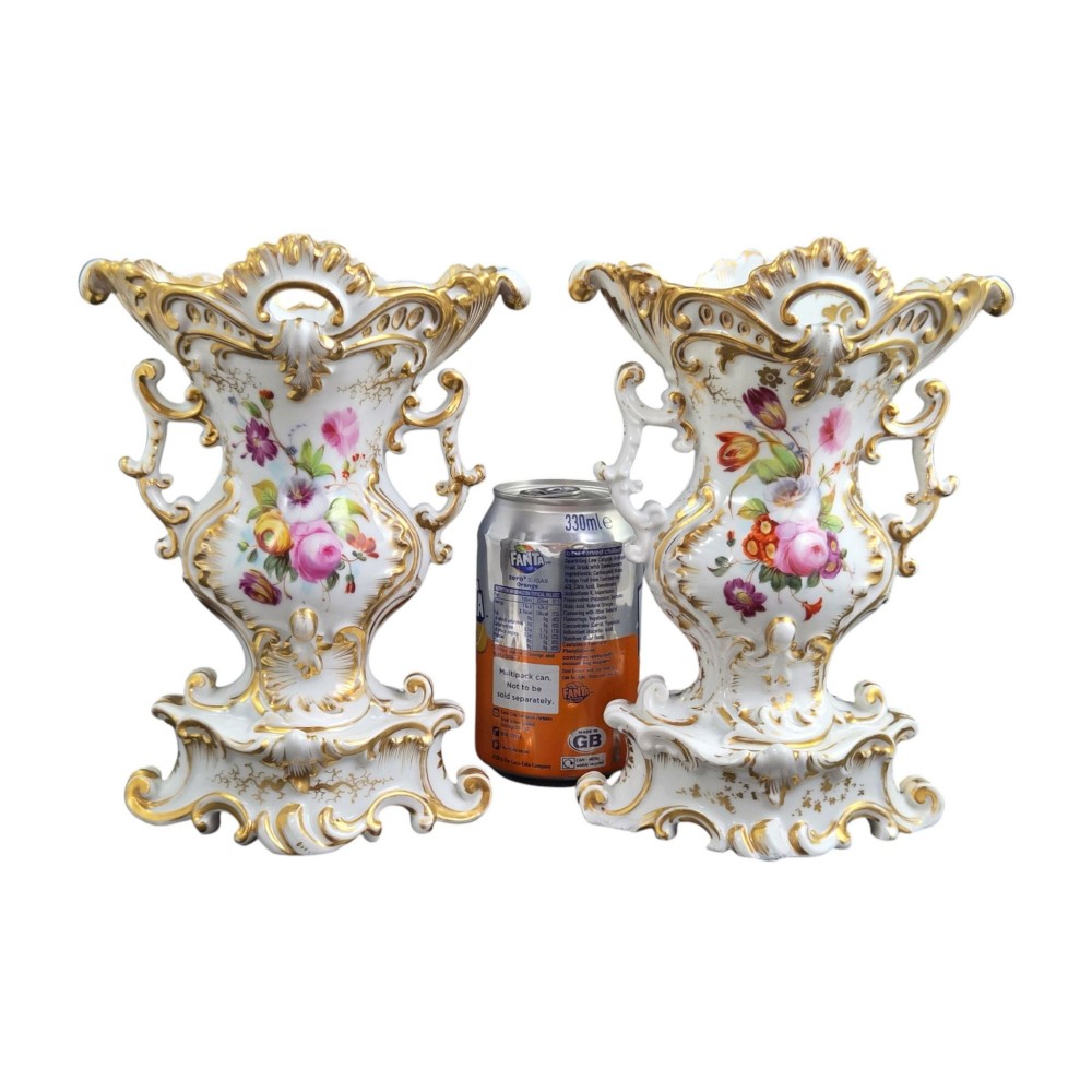 A pair of ornate white and gilded porcelain Rococo vases featuring hand-painted floral bouquets, pierced rims, and scroll handles. View VIII