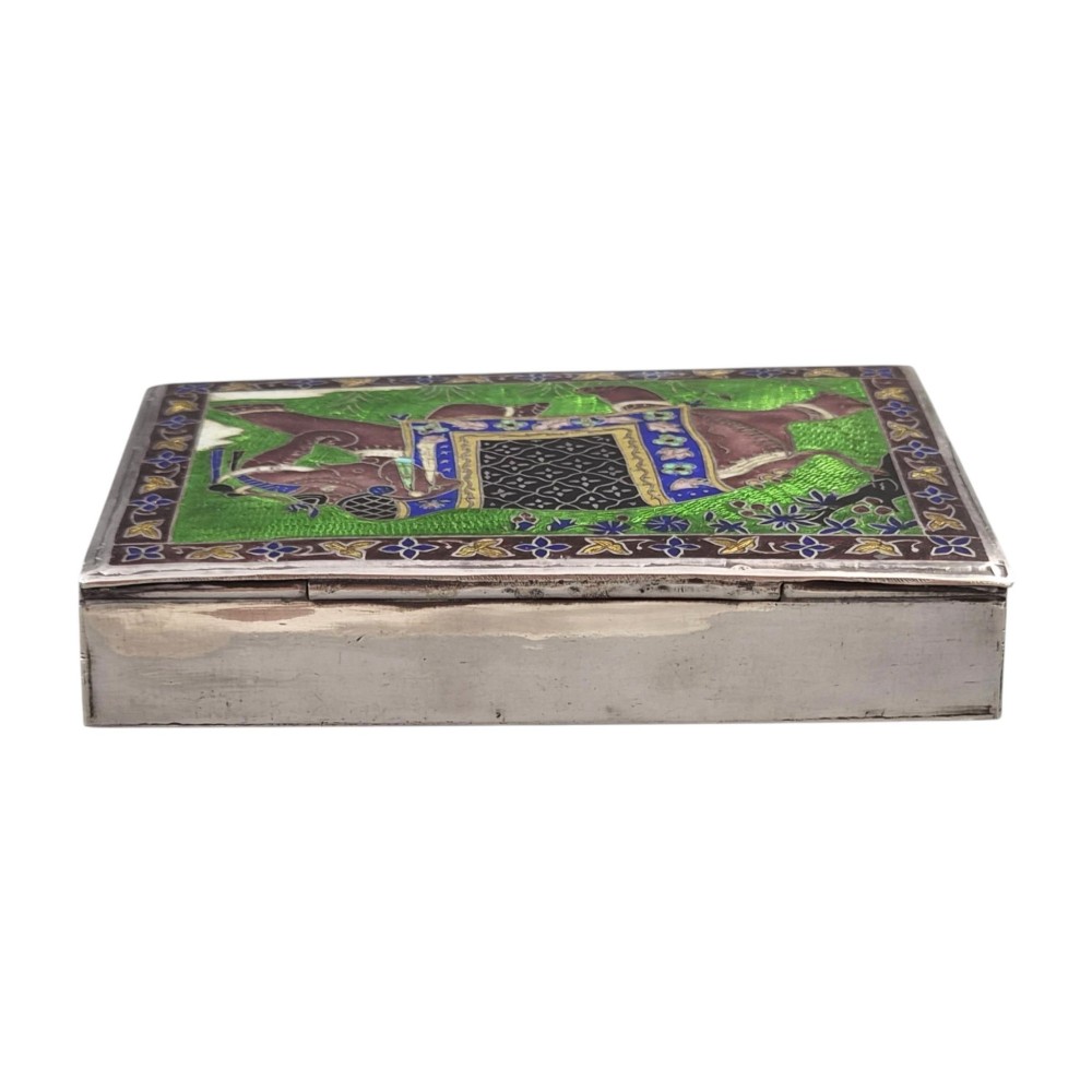 A rectangular sterling silver box featuring a colourful enamelled scene of a decorated Indian elephant set against a green background with a patterned border. View V