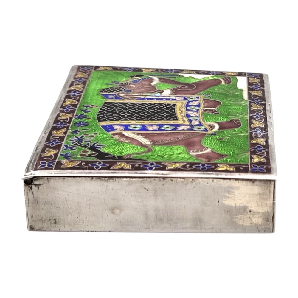 A rectangular sterling silver box featuring a colourful enamelled scene of a decorated Indian elephant set against a green background with a patterned border. View XI