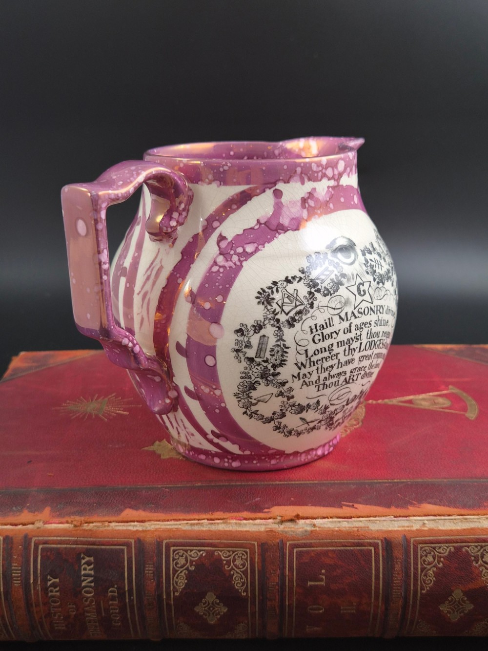 An English earthenware jug featuring pink splash lustre glaze trim and a central black transfer-printed Masonic emblem. View III