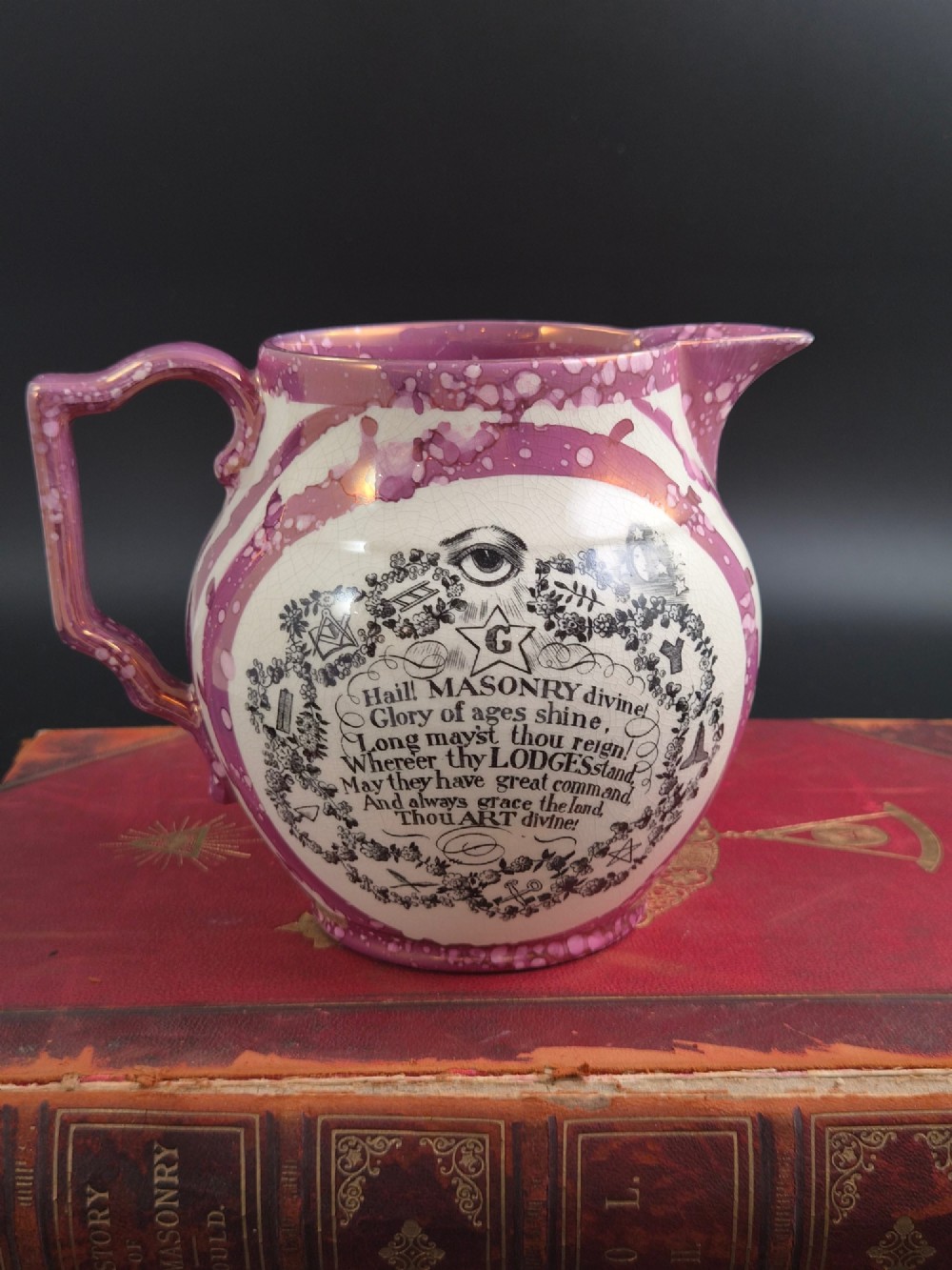An English earthenware jug featuring pink splash lustre glaze trim and a central black transfer-printed Masonic emblem. View IV