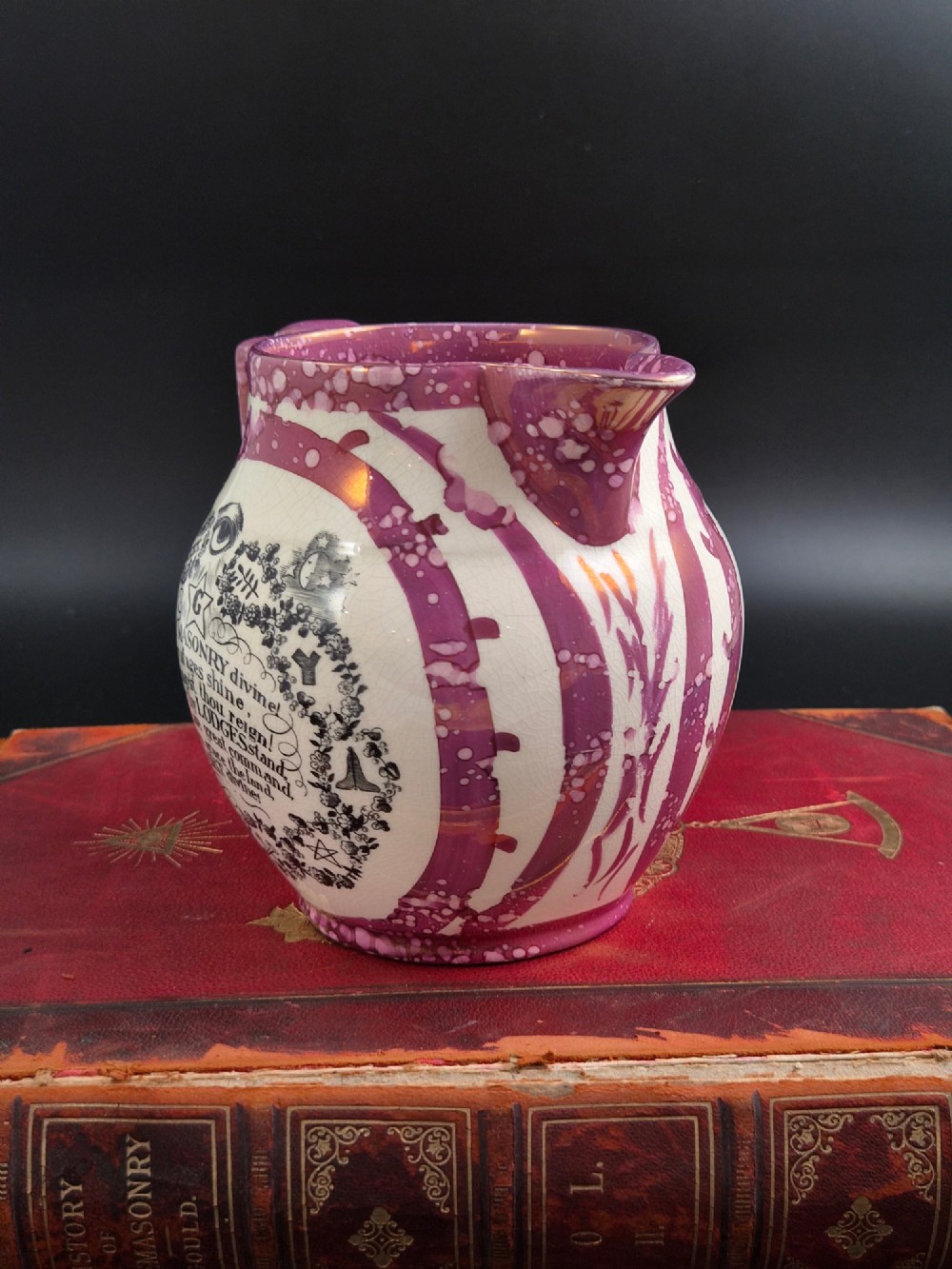 An English earthenware jug featuring pink splash lustre glaze trim and a central black transfer-printed Masonic emblem. View V