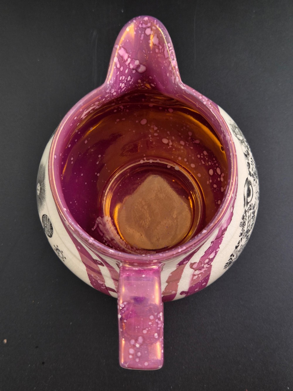 An English earthenware jug featuring pink splash lustre glaze trim and a central black transfer-printed Masonic emblem. View VII
