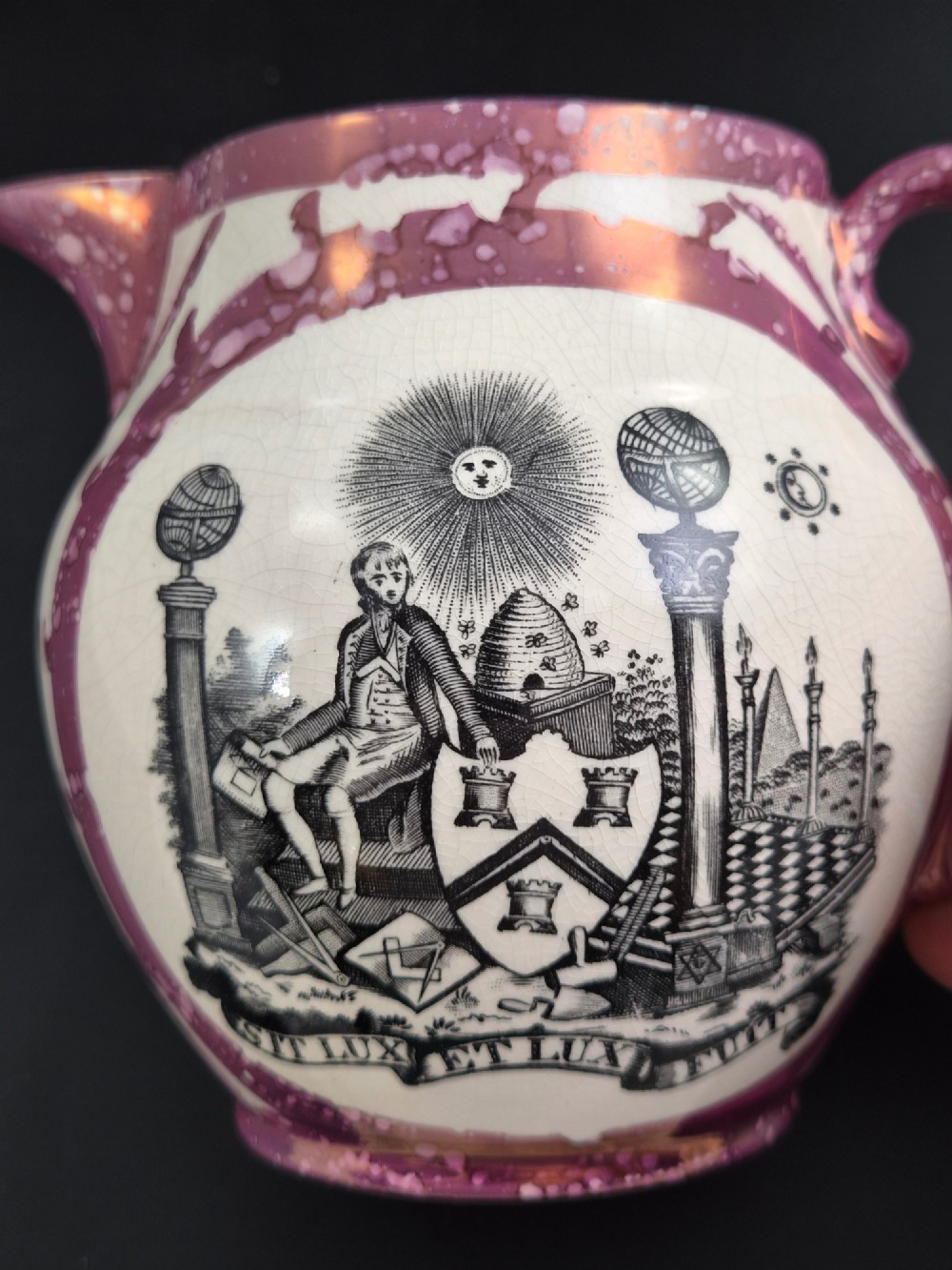 An English earthenware jug featuring pink splash lustre glaze trim and a central black transfer-printed Masonic emblem. View XI