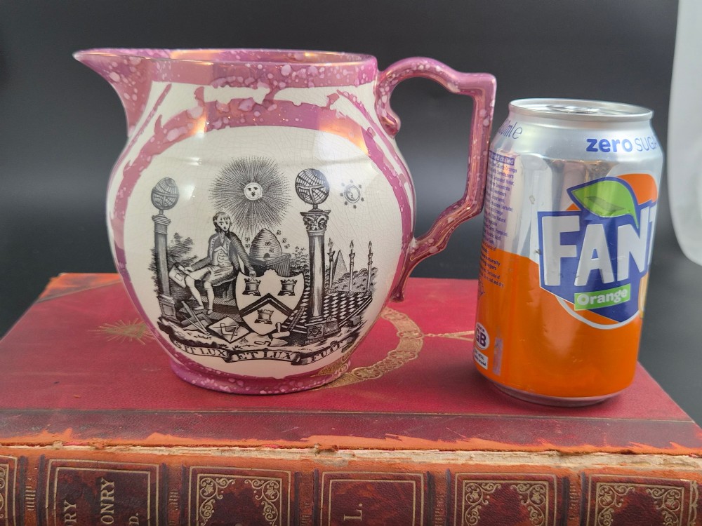 An English earthenware jug featuring pink splash lustre glaze trim and a central black transfer-printed Masonic emblem. View XII