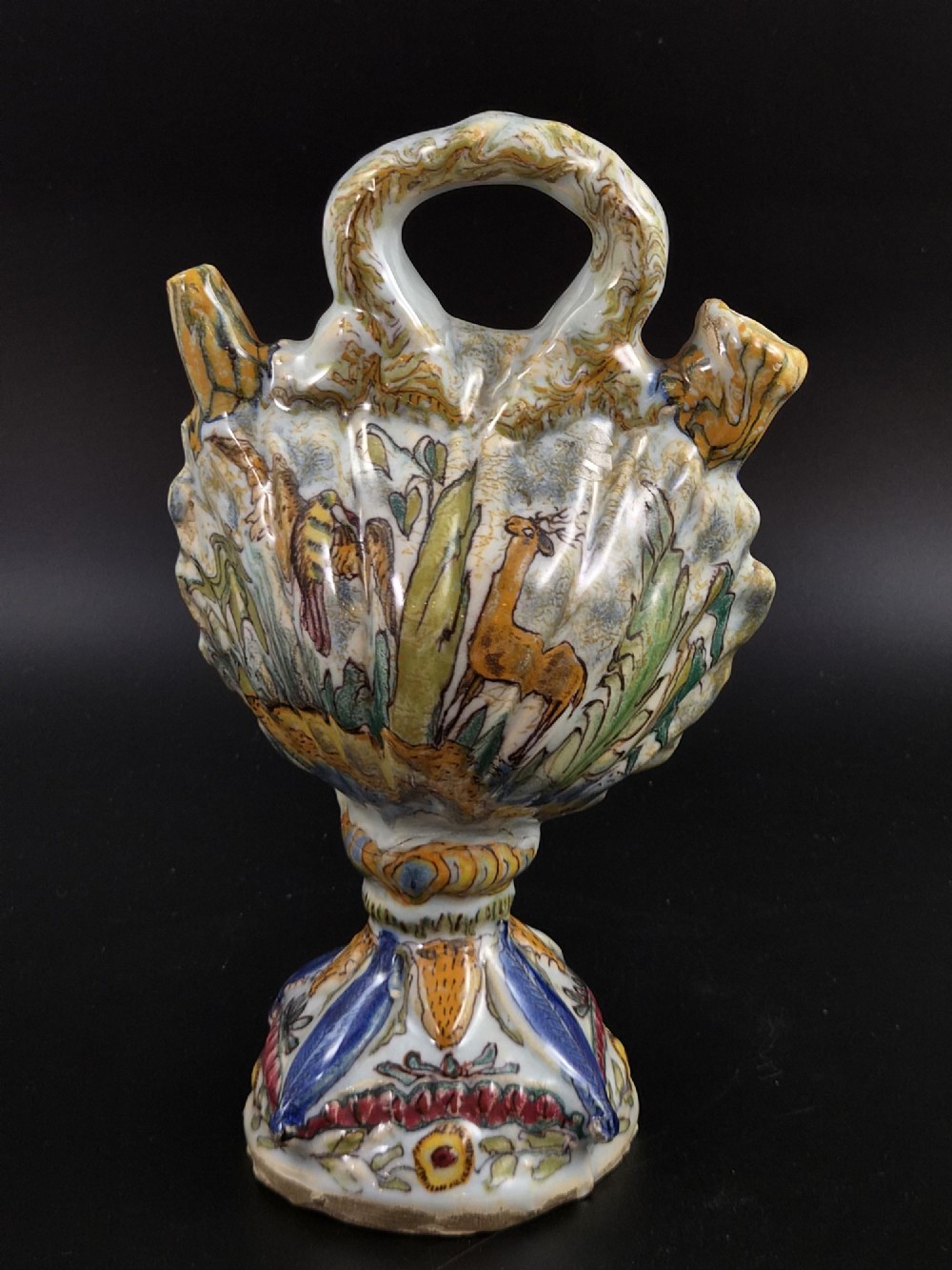 An 18th-century Italian majolica pilgrim flask featuring a scallop-shell body, twin spouts, loop handles, a pedestal foot, and hand-painted polychrome flora and fauna. View IV