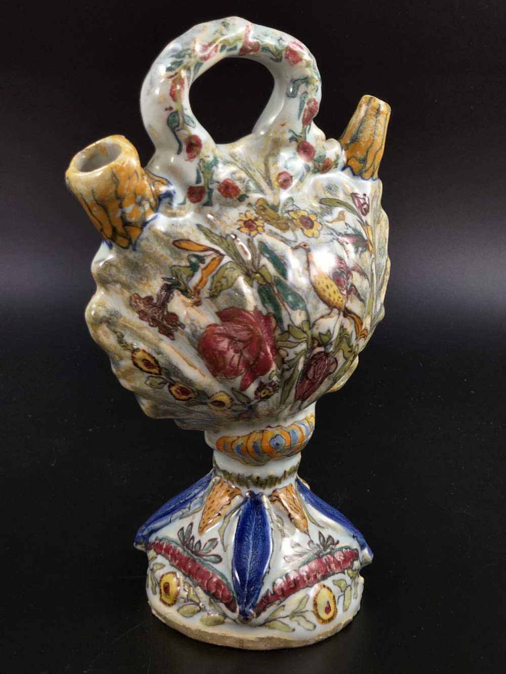 An 18th-century Italian majolica pilgrim flask featuring a scallop-shell body, twin spouts, loop handles, a pedestal foot, and hand-painted polychrome flora and fauna. View VI