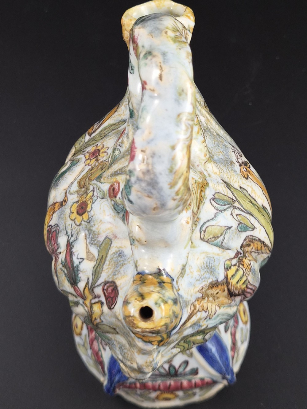 An 18th-century Italian majolica pilgrim flask featuring a scallop-shell body, twin spouts, loop handles, a pedestal foot, and hand-painted polychrome flora and fauna. View VII