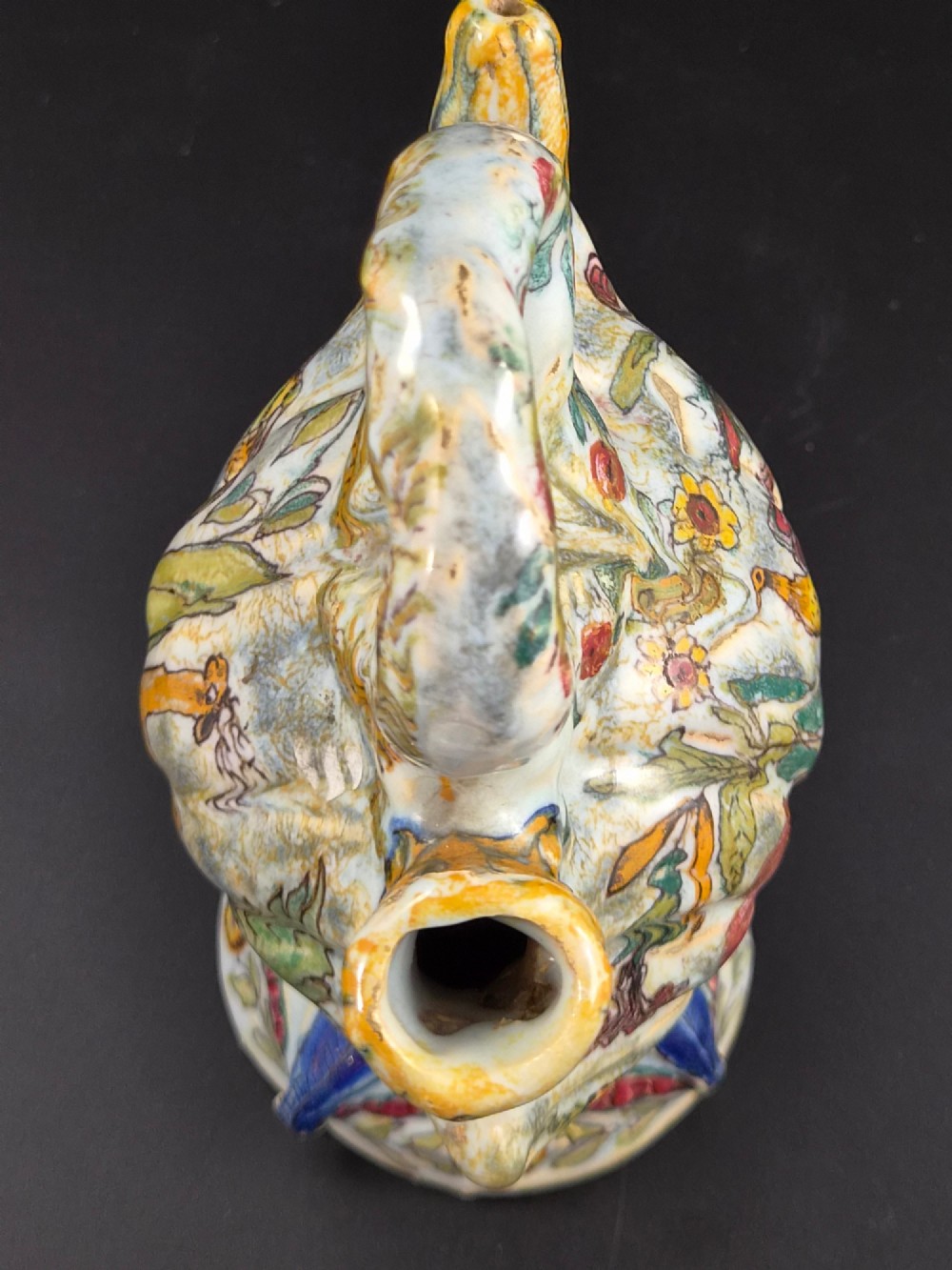 An 18th-century Italian majolica pilgrim flask featuring a scallop-shell body, twin spouts, loop handles, a pedestal foot, and hand-painted polychrome flora and fauna. View VIII