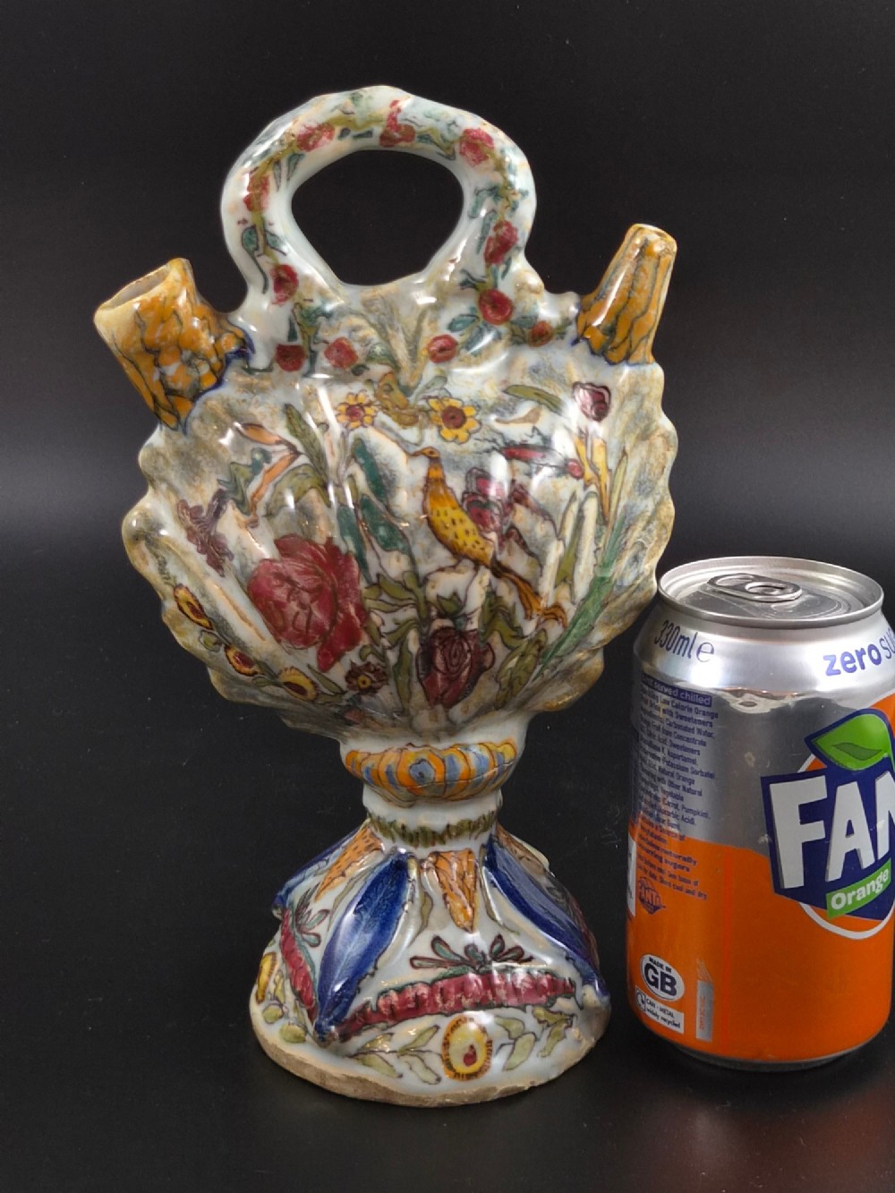 An 18th-century Italian majolica pilgrim flask featuring a scallop-shell body, twin spouts, loop handles, a pedestal foot, and hand-painted polychrome flora and fauna. View XI