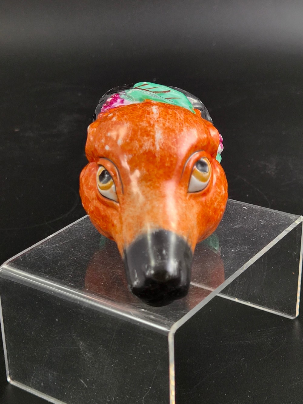 A 19th-century Royal Staffordshire porcelain stirrup cup molded in the form of a fox head with painted orange, black, green, and purple enamels. View II
