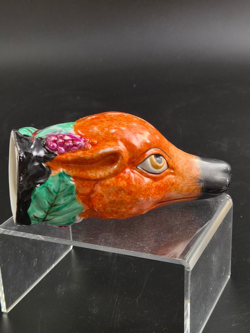 A 19th-century Royal Staffordshire porcelain stirrup cup molded in the form of a fox head with painted orange, black, green, and purple enamels. View IV