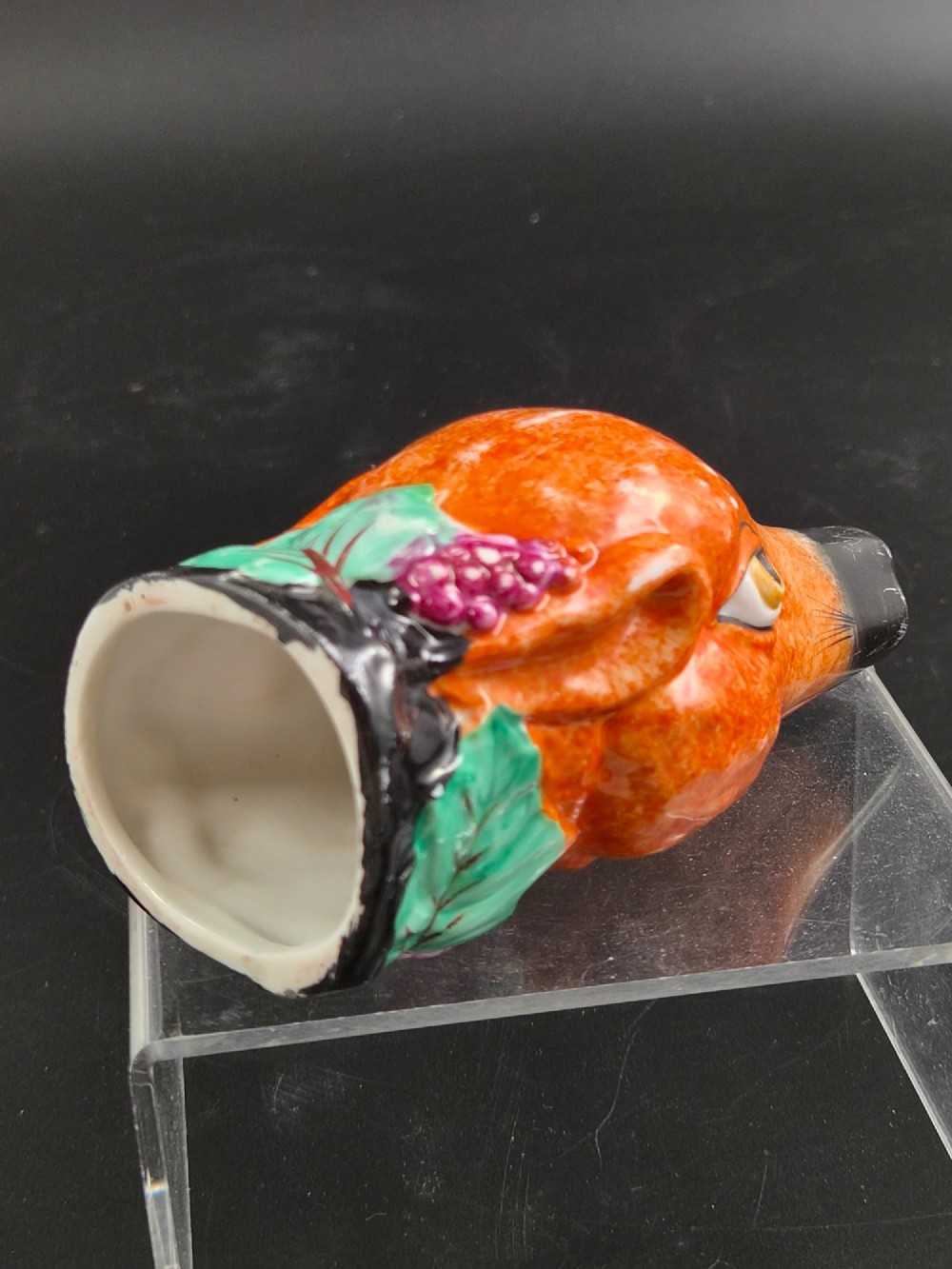 A 19th-century Royal Staffordshire porcelain stirrup cup molded in the form of a fox head with painted orange, black, green, and purple enamels. View V
