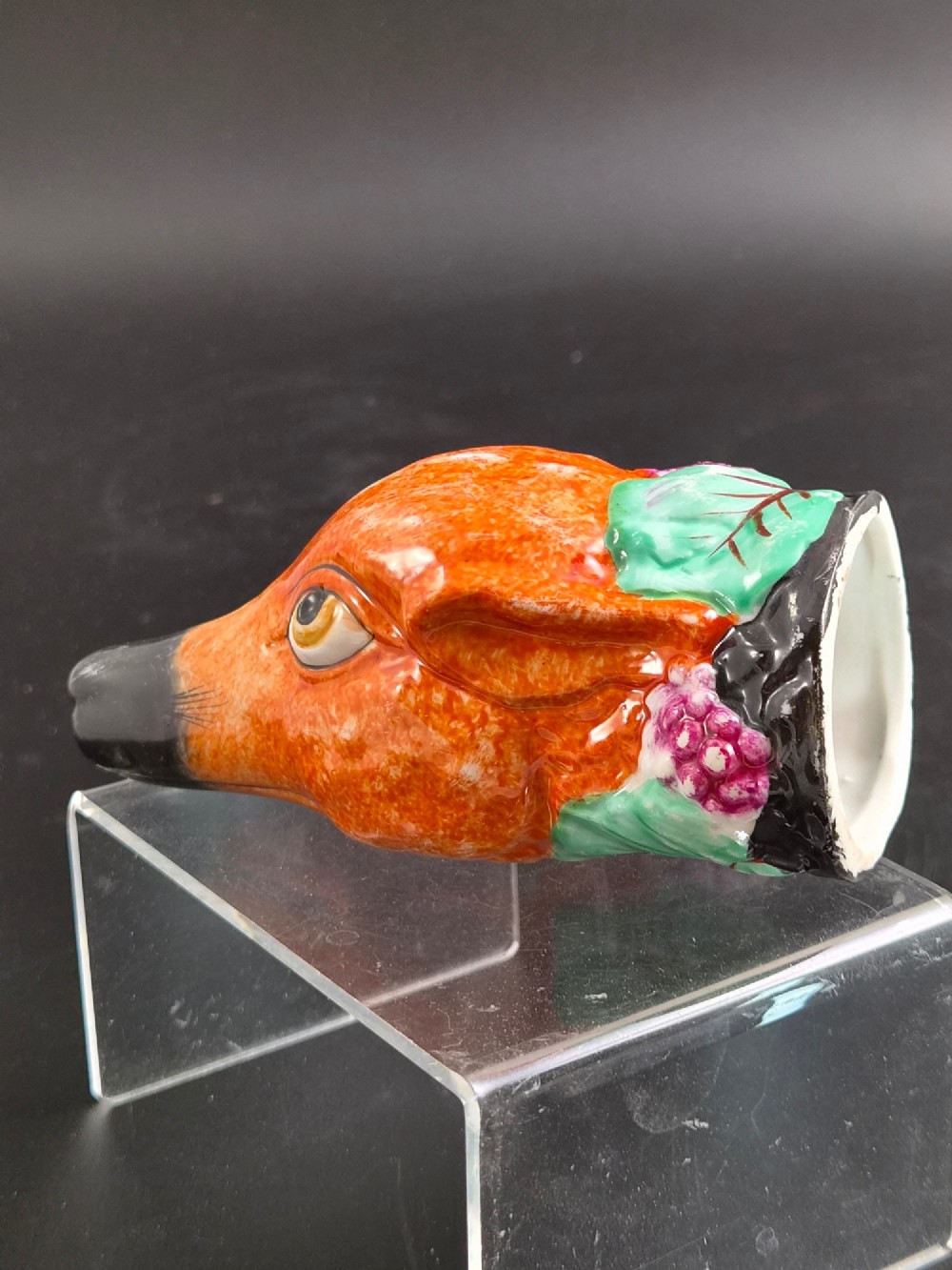 A 19th-century Royal Staffordshire porcelain stirrup cup molded in the form of a fox head with painted orange, black, green, and purple enamels. View VII