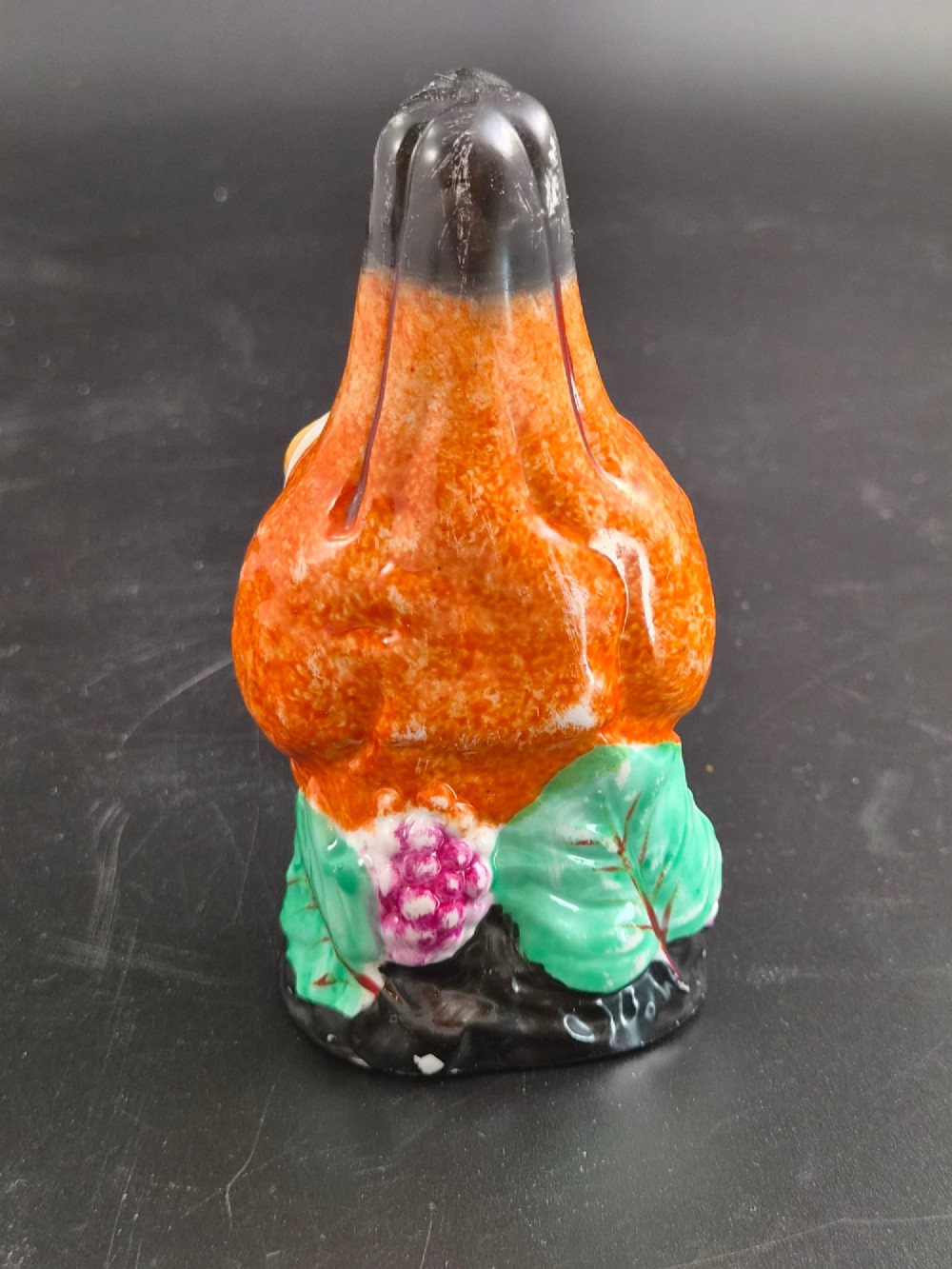 A 19th-century Royal Staffordshire porcelain stirrup cup molded in the form of a fox head with painted orange, black, green, and purple enamels. View IX