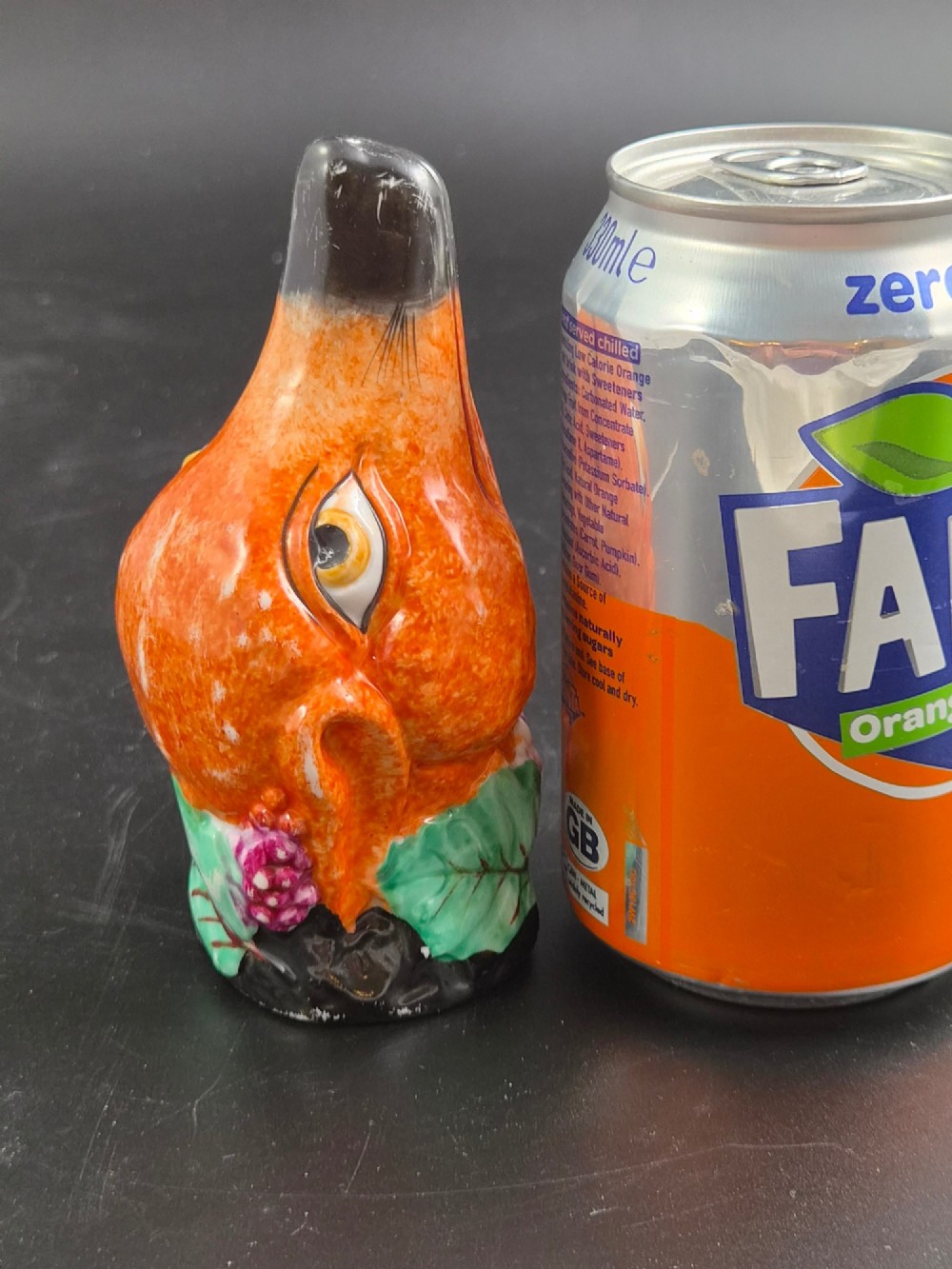 A 19th-century Royal Staffordshire porcelain stirrup cup molded in the form of a fox head with painted orange, black, green, and purple enamels. View X