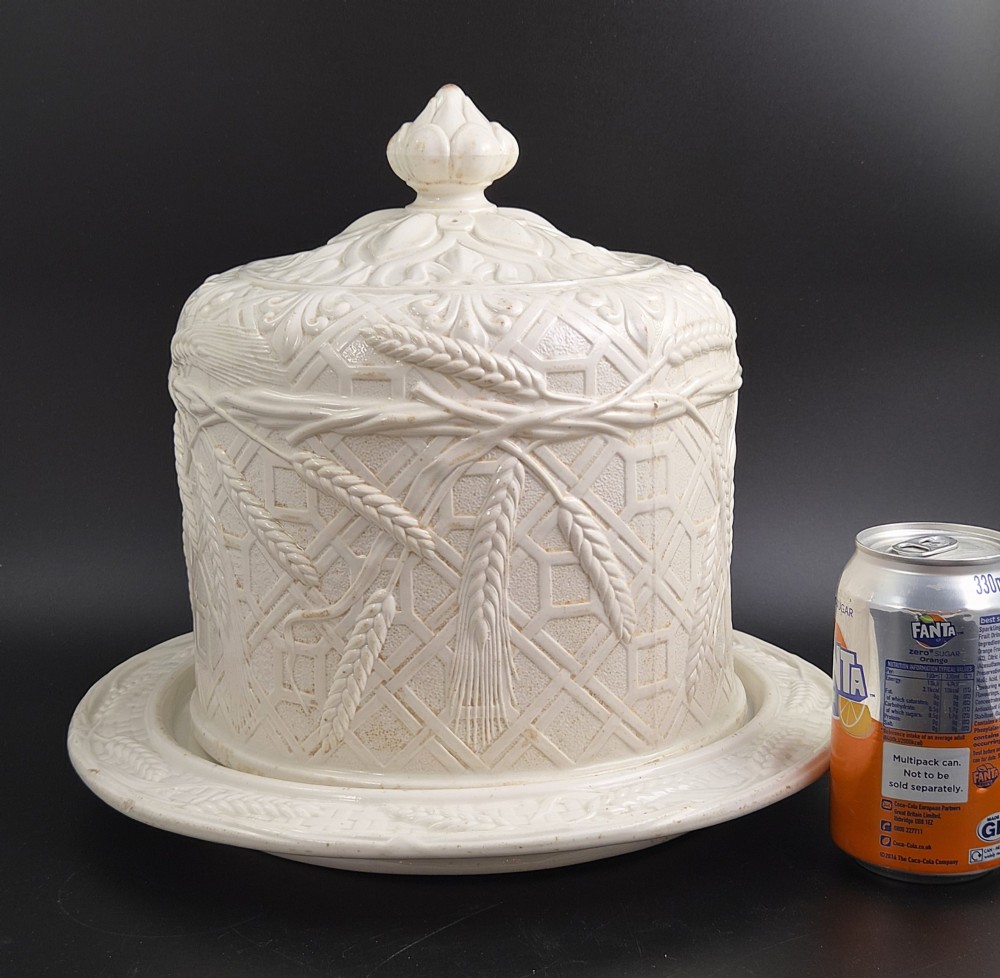 An off-white Victorian ironstone cheese dome and matching circular stand with molded relief lattice work and wheat sheaf motifs. View VIII