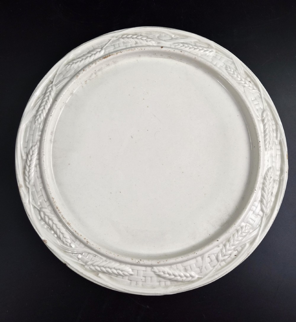An off-white Victorian ironstone cheese dome and matching circular stand with molded relief lattice work and wheat sheaf motifs. View IX
