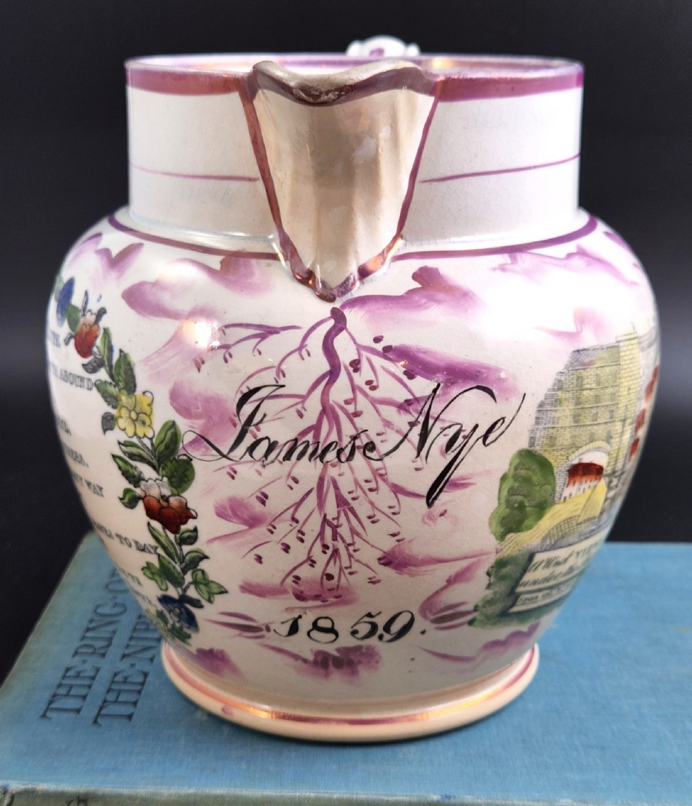 An antique cream earthenware jug decorated with pink splash lustre glaze and a central transfer print depicting the Iron Bridge over the Wear. View VI