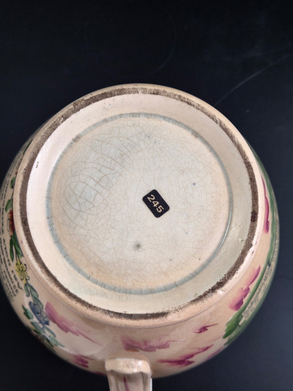 An antique cream earthenware jug decorated with pink splash lustre glaze and a central transfer print depicting the Iron Bridge over the Wear. View VIII