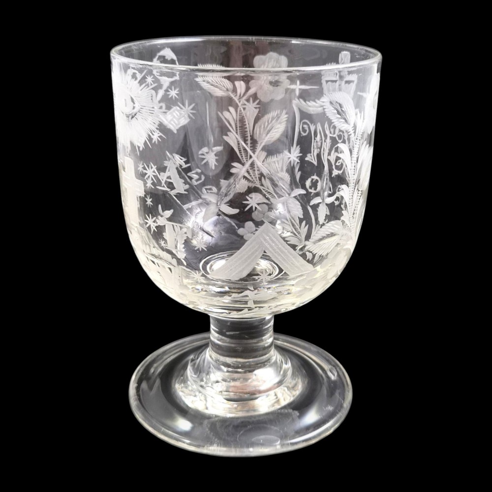 A clear lead-glass rummer featuring detailed wheel-engraved fraternal symbols, including a central cross, all-seeing eye, crowns, and floral garlands, resting on a short stem and circular foot. View II