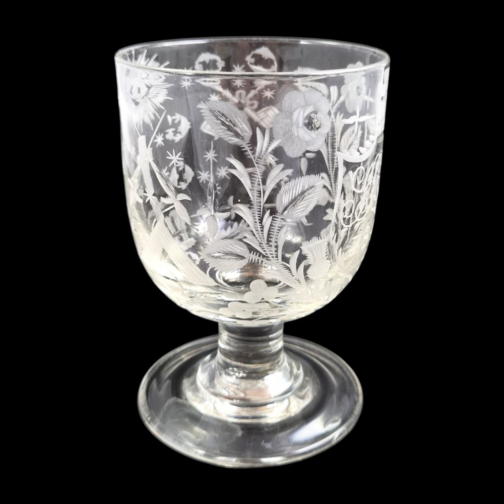 A clear lead-glass rummer featuring detailed wheel-engraved fraternal symbols, including a central cross, all-seeing eye, crowns, and floral garlands, resting on a short stem and circular foot. View III