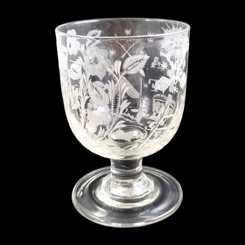 A clear lead-glass rummer featuring detailed wheel-engraved fraternal symbols, including a central cross, all-seeing eye, crowns, and floral garlands, resting on a short stem and circular foot. View VI