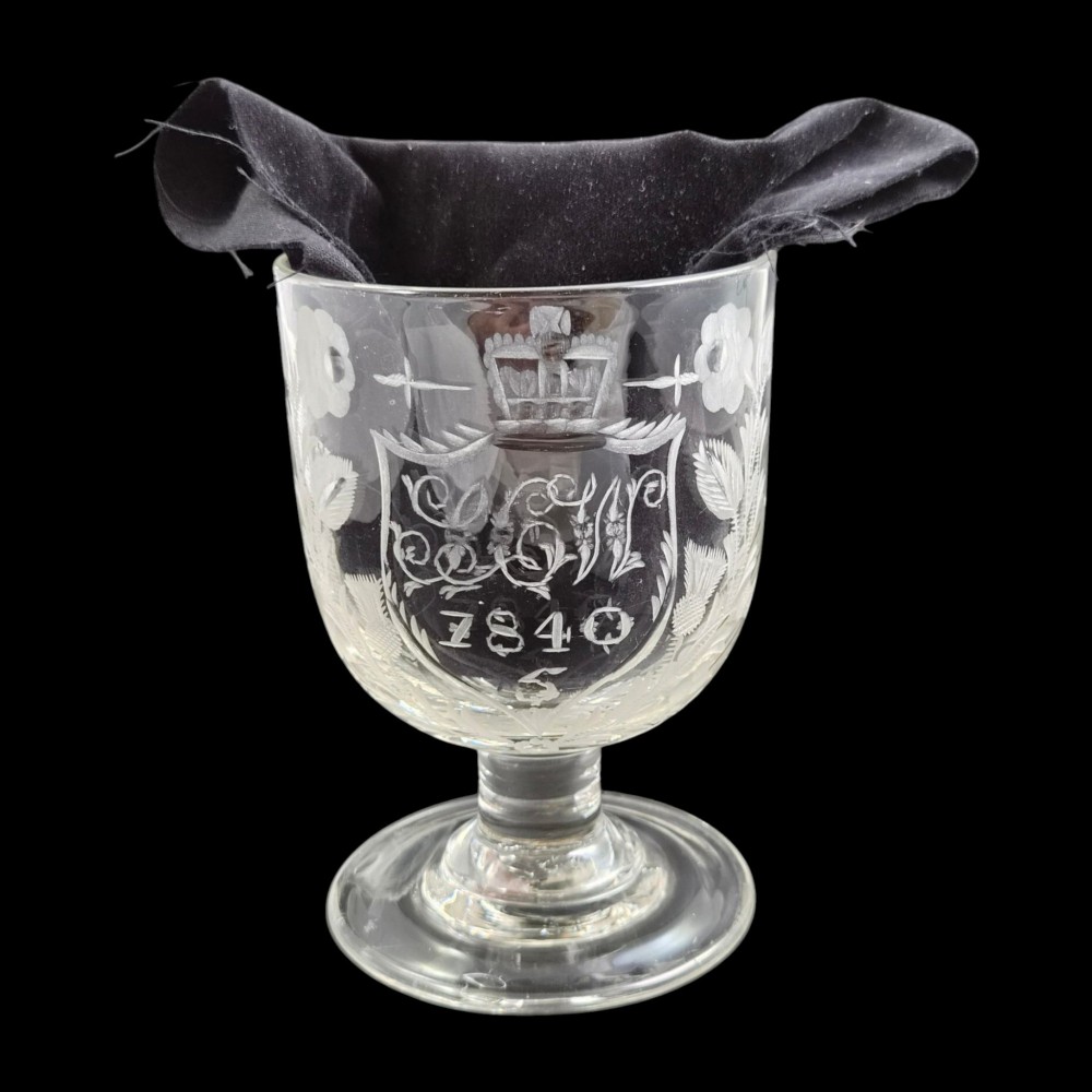 A clear lead-glass rummer featuring detailed wheel-engraved fraternal symbols, including a central cross, all-seeing eye, crowns, and floral garlands, resting on a short stem and circular foot. View VII