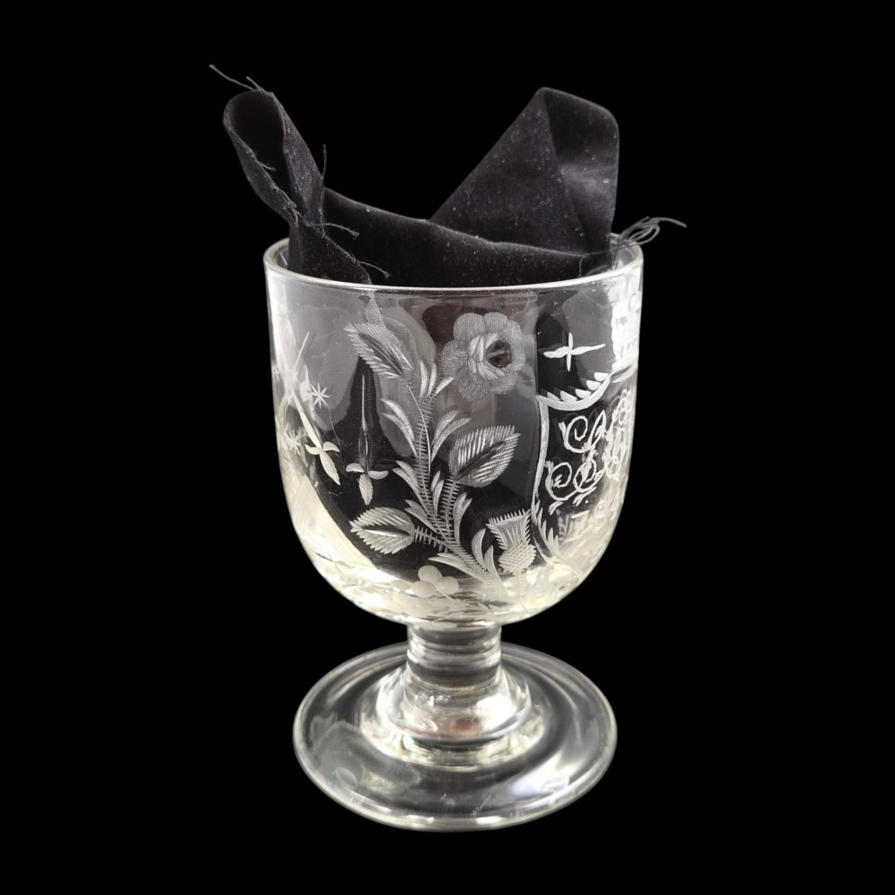 A clear lead-glass rummer featuring detailed wheel-engraved fraternal symbols, including a central cross, all-seeing eye, crowns, and floral garlands, resting on a short stem and circular foot. View VIII