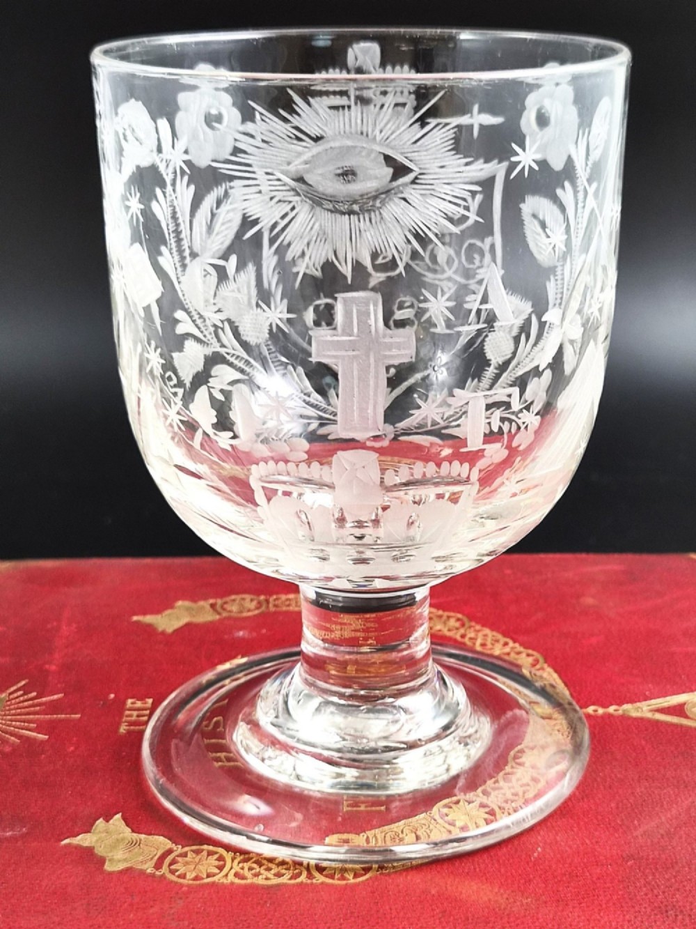 A clear lead-glass rummer featuring detailed wheel-engraved fraternal symbols, including a central cross, all-seeing eye, crowns, and floral garlands, resting on a short stem and circular foot. View XIII