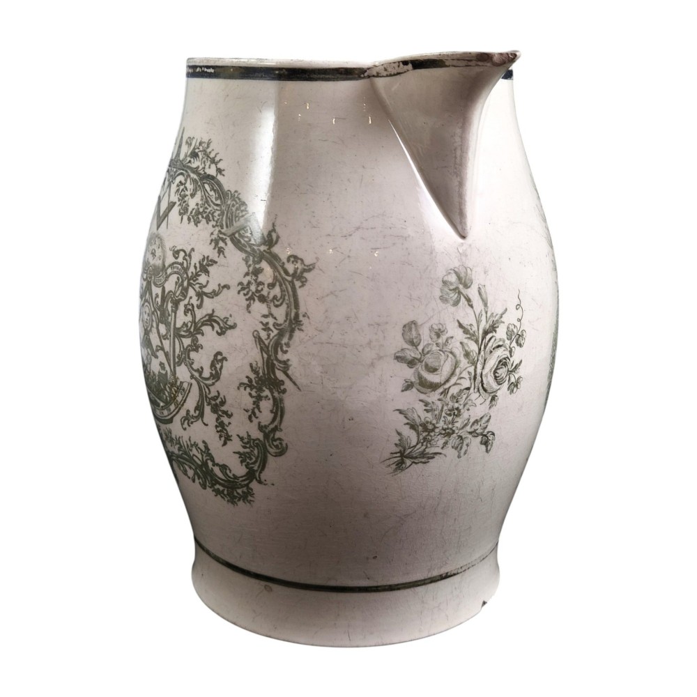 A Georgian Staffordshire creamware jug featuring transfer-printed olive-green Masonic iconography framed by a leafy scrollwork wreath. View III
