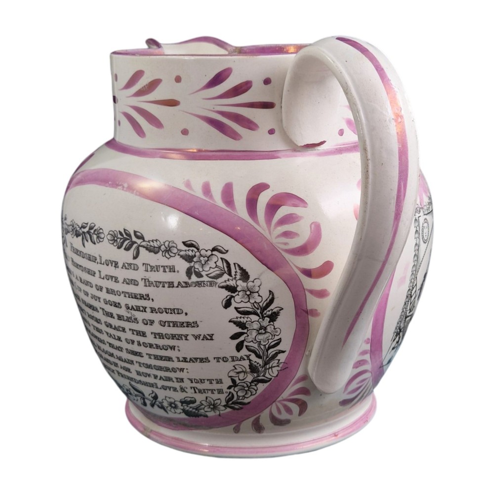 An antique white earthenware jug decorated with pink metallic lustre foliage borders and a black transfer-printed Masonic emblem featuring twin columns and symbolic motifs. View VI