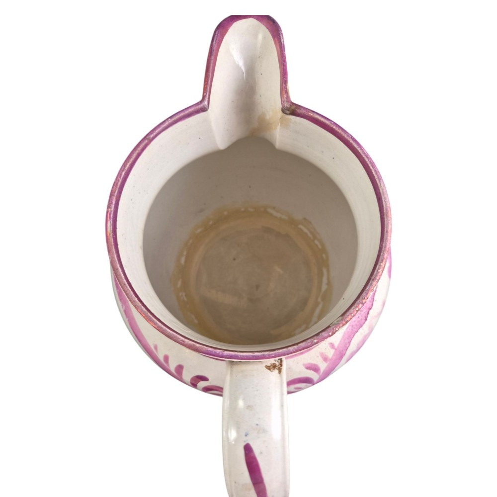 An antique white earthenware jug decorated with pink metallic lustre foliage borders and a black transfer-printed Masonic emblem featuring twin columns and symbolic motifs. View X