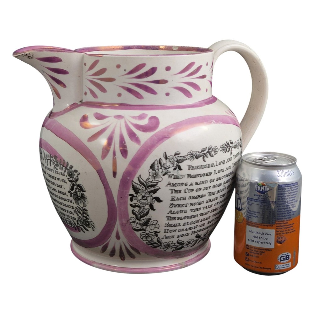 An antique white earthenware jug decorated with pink metallic lustre foliage borders and a black transfer-printed Masonic emblem featuring twin columns and symbolic motifs. View XIII