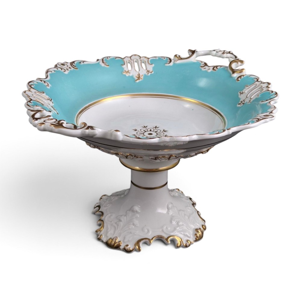 A Victorian Coalport bone china tazza featuring a turquoise border, central floral motif, gilded scroll accents, and a footed stem base.