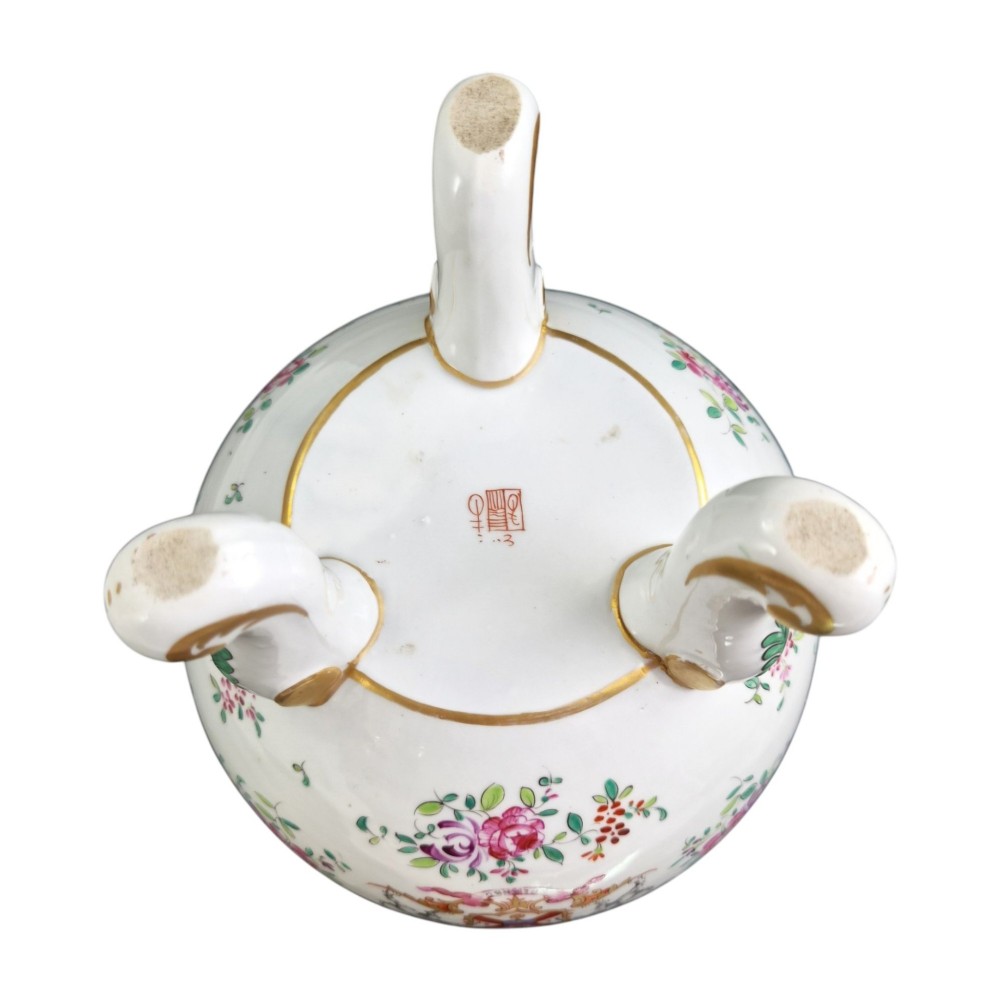 A white hard-paste porcelain covered jar on three cabriole legs, decorated with floral enamel sprays, an armorial crest, green lattice borders, and topped with a foo dog lid finial. View XII