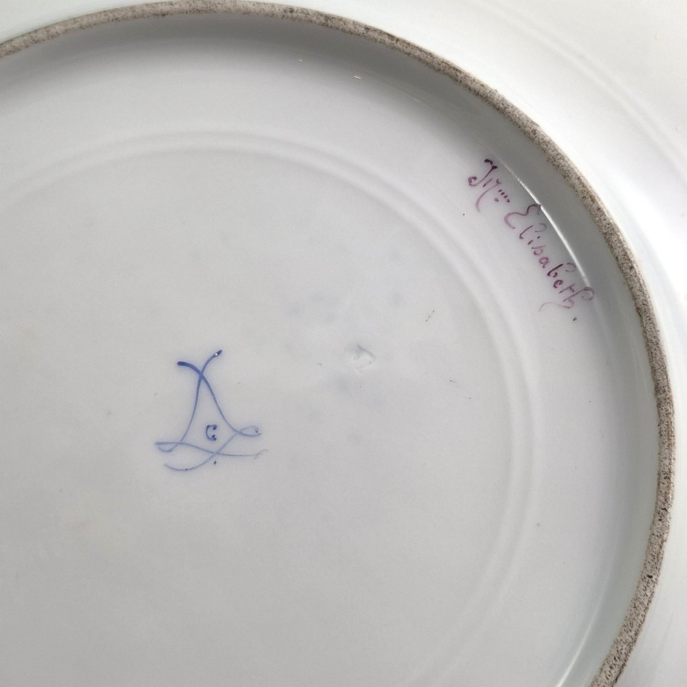 A circular porcelain cabinet plate featuring a central hand-painted portrait of a woman framed by a deep cobalt blue rim with gold scrollwork. View V
