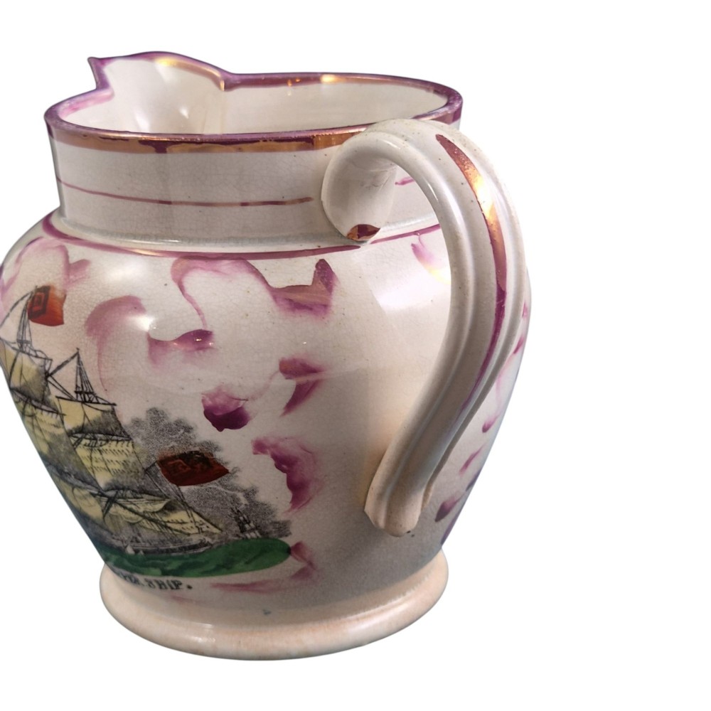 An antique cream earthenware jug featuring pink splash lustre decoration and a hand-coloured transfer print of Masonic coats of arms. View V