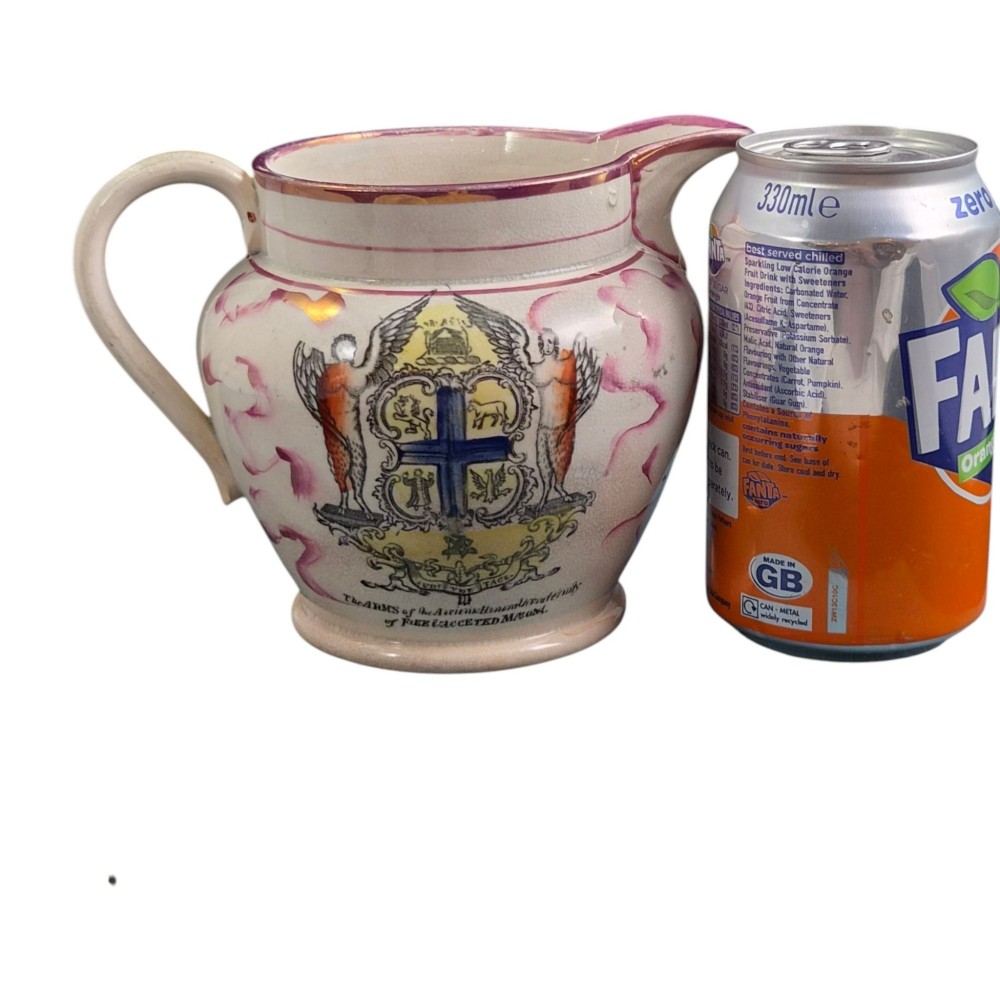 An antique cream earthenware jug featuring pink splash lustre decoration and a hand-coloured transfer print of Masonic coats of arms. View X