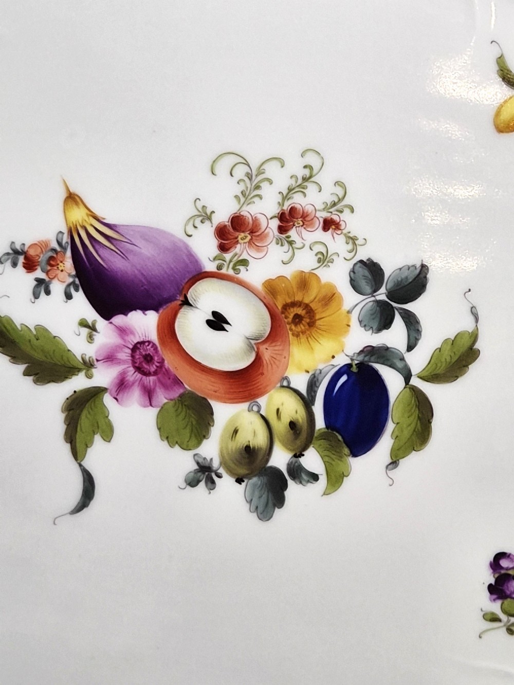 An oval white porcelain tray featuring hand-painted fruit and insect motifs, moulded basketweave border, pink painted ribbon handles, and a gilded rim. View III