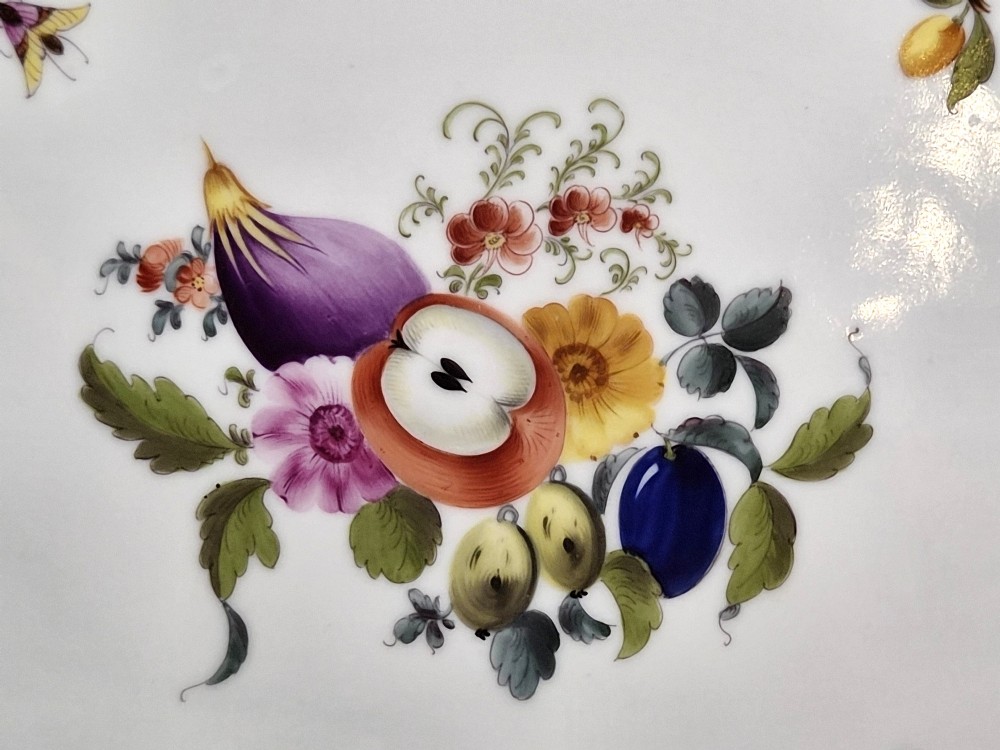 An oval white porcelain tray featuring hand-painted fruit and insect motifs, moulded basketweave border, pink painted ribbon handles, and a gilded rim. View V