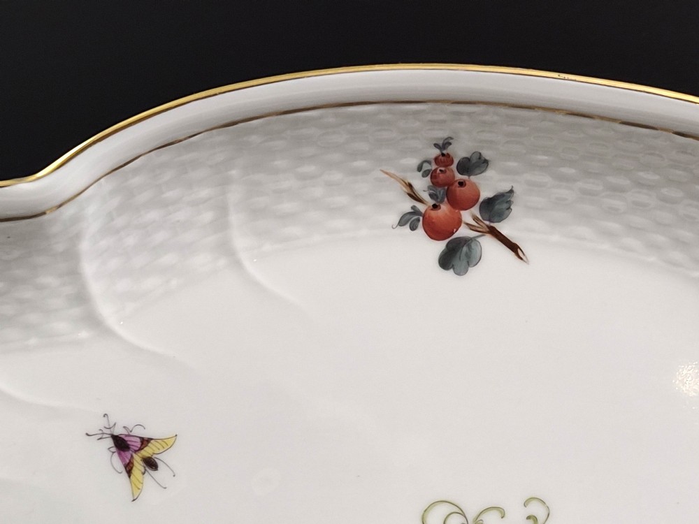 An oval white porcelain tray featuring hand-painted fruit and insect motifs, moulded basketweave border, pink painted ribbon handles, and a gilded rim. View VI