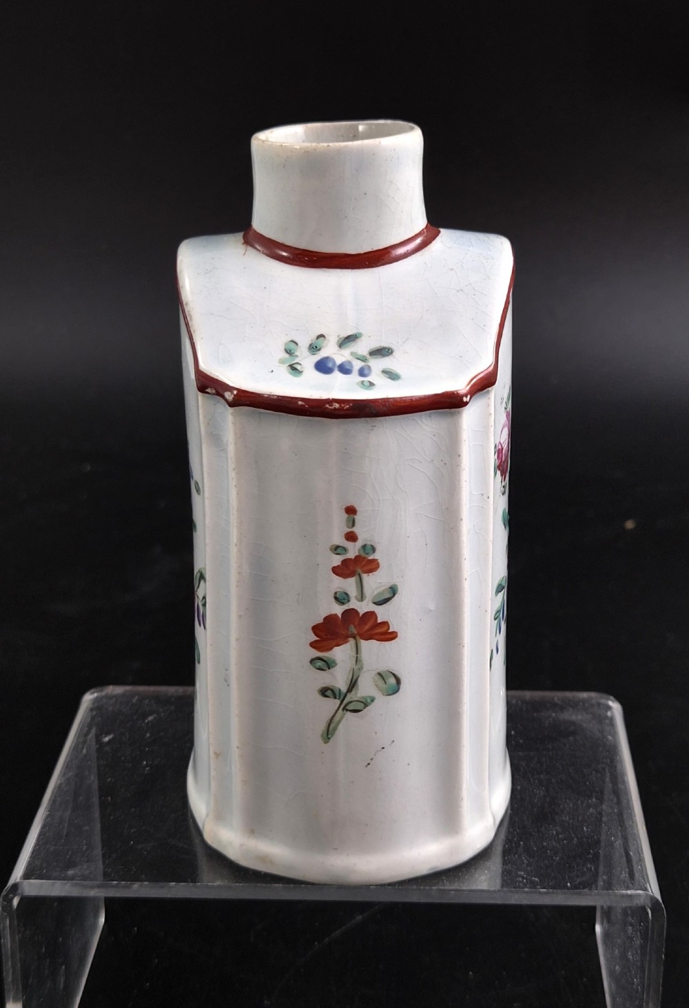 An eighteenth-century creamware tea canister with hand-painted floral enamel motifs in purple, red, and green on an off-white earthenware body with arched reddish-brown shoulders. View IV