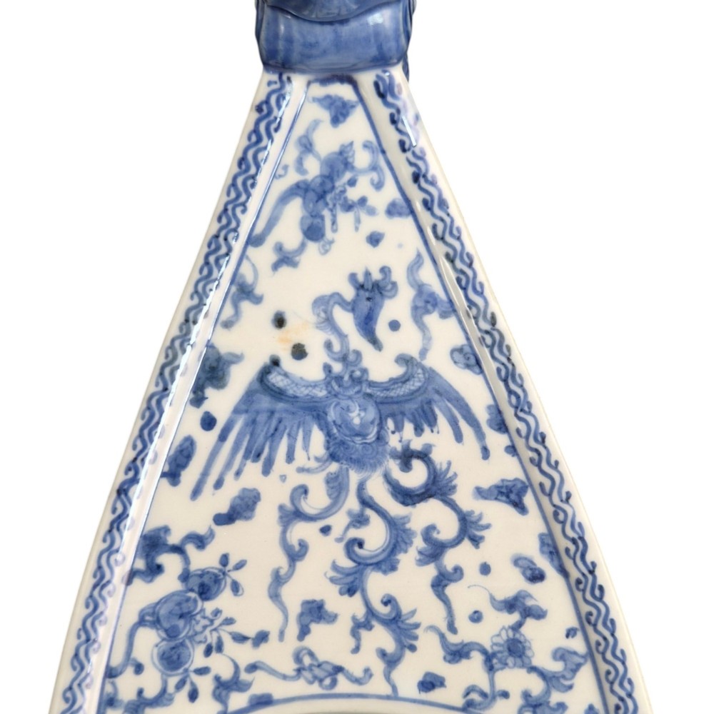 A Japanese blue and white porcelain vessel shaped like a boat featuring a carved dragon figurehead at the prow. View III
