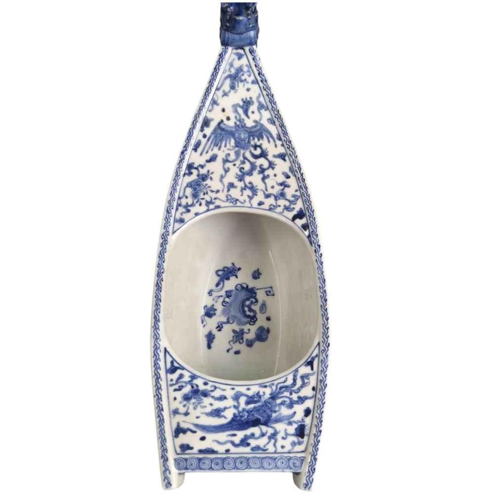 A Japanese blue and white porcelain vessel shaped like a boat featuring a carved dragon figurehead at the prow. View IV