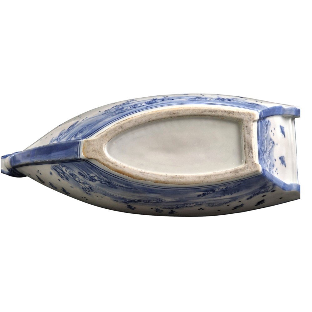 A Japanese blue and white porcelain vessel shaped like a boat featuring a carved dragon figurehead at the prow. View XI