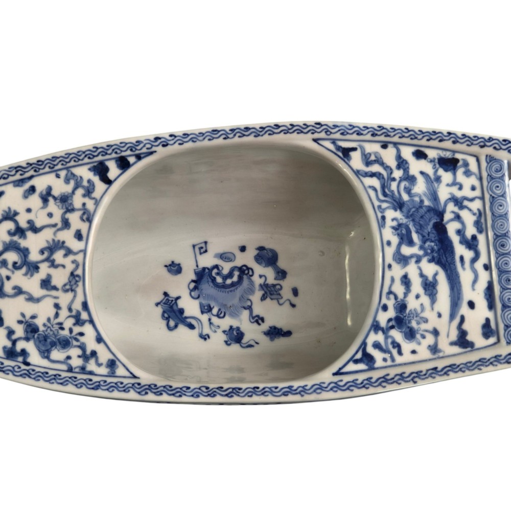 A Japanese blue and white porcelain vessel shaped like a boat featuring a carved dragon figurehead at the prow. View XIII