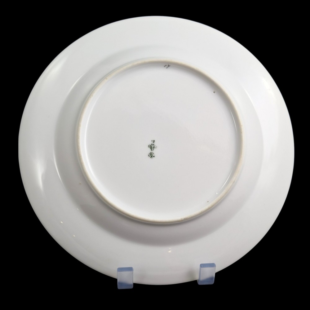 A circular white porcelain plate with twin gilded rim borders and a small Russian Imperial double-headed eagle crest near the top edge. View IV