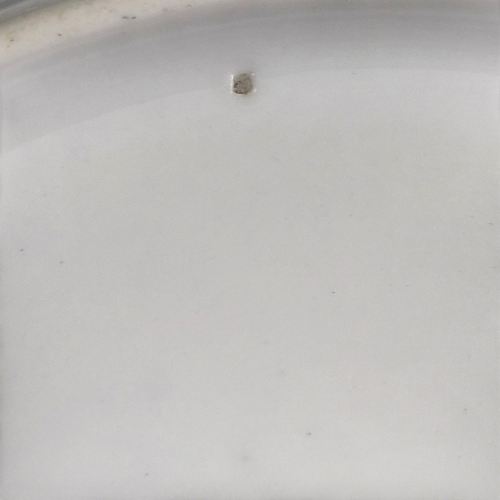 A circular white porcelain plate with twin gilded rim borders and a small Russian Imperial double-headed eagle crest near the top edge. View IX