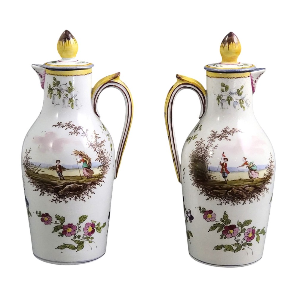 A pair of 18th-century white tin-glazed earthenware oil and vinegar jugs decorated with hand-painted floral motifs and fitted with yellow finial covers. View VIII